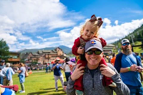 Daughter on father's shoulders at a summer event in Winter Park Resort