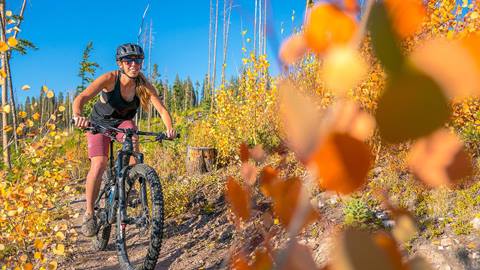 Woman riding a bike in the fall at Winter Park Resort