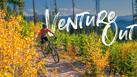 Women riding bike through fall foliage