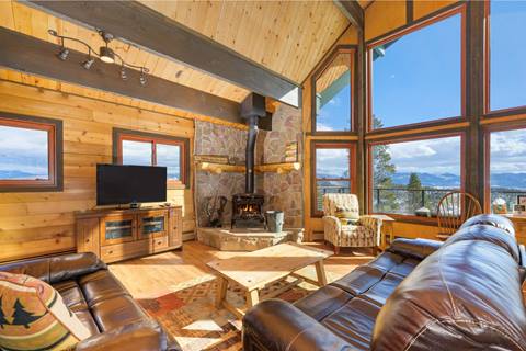 Log cabin living room with high ceiling and floor to ceiling windows