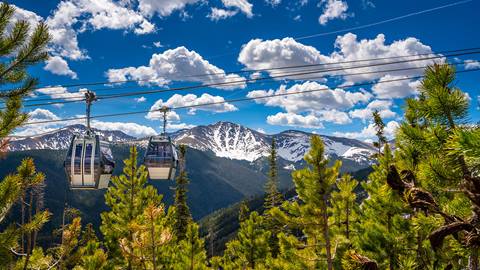 Winter Park Scenic Gondola ascending over the rocky mountain and forests 