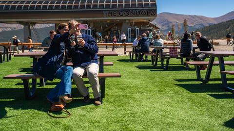 People sitting on benches at ski resort in Colorado during the summer