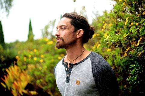 Profile of a man surrounded by greenery. 