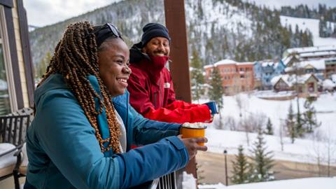 Man and women on hotel deck at ski resort