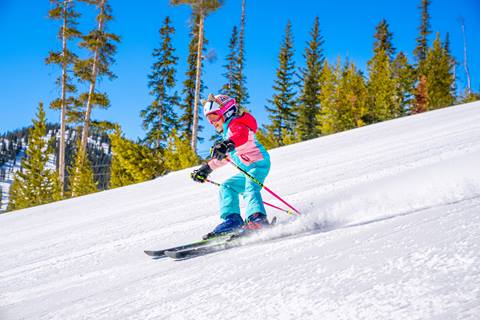 Child skiing in bright outfit at Winter Park Resort Colorado