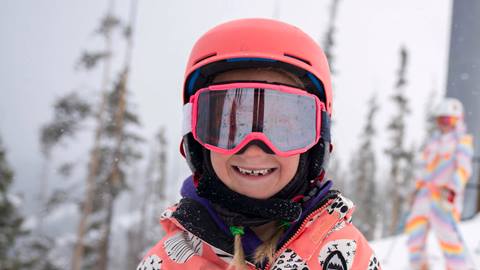 Child in pink ski gear on mountain at Winter Park Resort